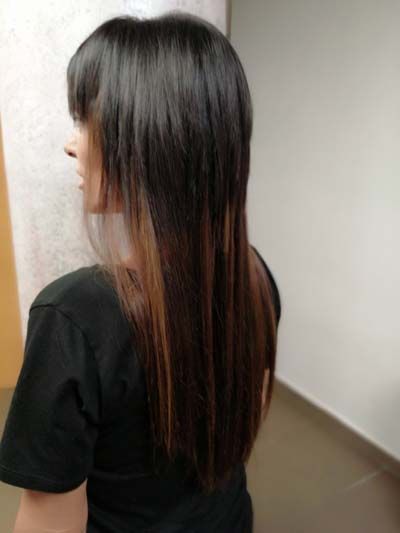 Chica presentando resultado del acabado de una extensión de pelo