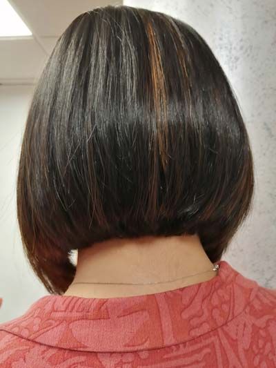 Vistra trasera de acabado de pelo corto oscuro con alguna mecha de color